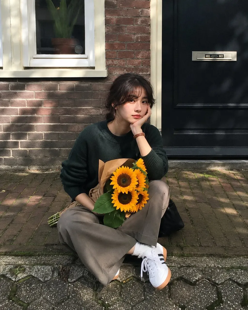 Asian woman with sunflowers on European sidewalk